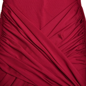 Vue macro détaillée du tissu rouge foncé montrant une texture plissée et un design drapé