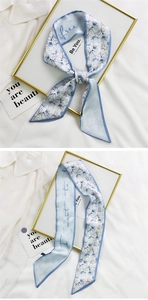 Detail of light blue floral hair ribbon with hand-written script on satin fabric