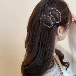 Primo piano di fermagli per capelli leopardati indossati da una modella su capelli lunghi
