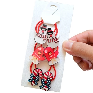 Close-up of Christmas hair ties set featuring snowman, gloves and candy canes on card
