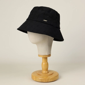Close-up of black quilted cotton bucket hat with a small metallic logo bar on the side