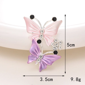 Dettaglio della spilla a farfalla 5x3,5cm rosa e viola con strass e smalto lucido