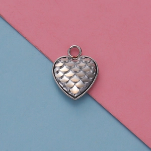 Dettaglio macro del ciondolo a cuore in acciaio inossidabile con incisione a scaglie