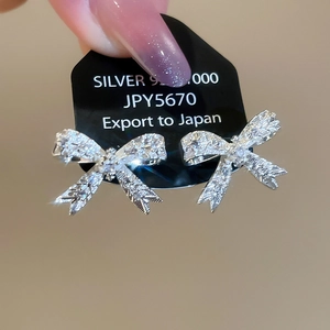 Vue rapprochée de boucles d'oreilles nœud en argent 925 avec zircons brillants et rubans