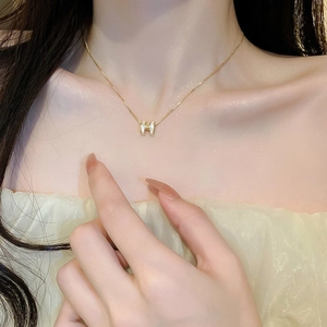 Zircon H-pendant necklace with gold plating on female model for a chic clavicle look