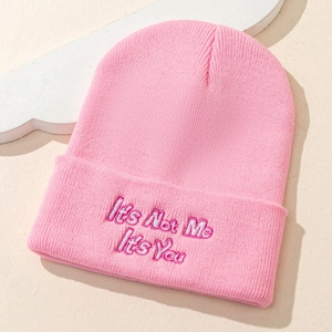 Gros plan du bonnet rose avec l'inscription It's Not Me It's You brodée sur le revers