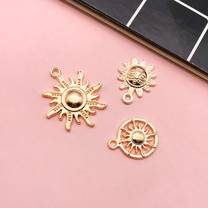 Detailed view of three gold sun alloy charms for DIY bracelets and earrings