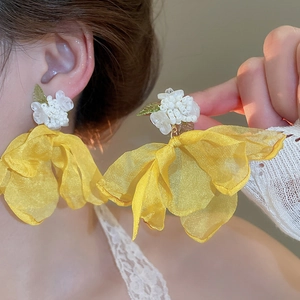 Detail of yellow tulle flower earrings with beaded accents and petal textures