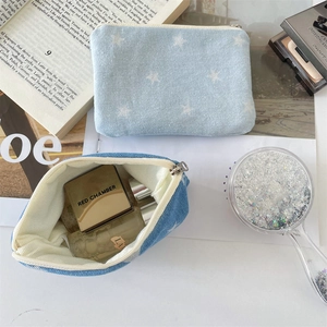 Detail of denim coin purses with star prints, showcasing interior space for cosmetics