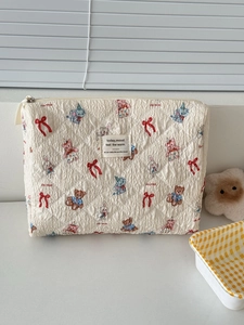 Quilted cream cosmetic bag with cute cartoon animal prints and a metal zipper closure