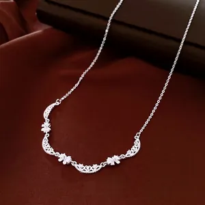 Elegant silver bow pendant necklace with floral scrollwork and sparkling crystals on satin