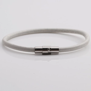 Dettaglio del bracciale in pelle bianca con chiusura magnetica in argento su fondo