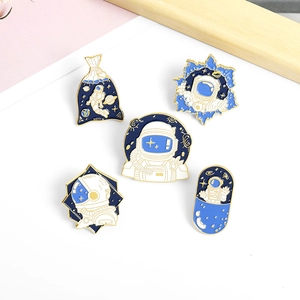 Detailed set of astronaut enamel pins with blue and gold space themes on white background