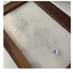 Close-up of S925 sterling silver necklace featuring a blue heart-shaped zircon pendant