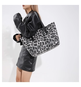 Fashionable black and white leopard print tote bag shown on model with black outfit