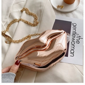 Close-up of rose gold lip-shaped clutch bag with sleek metal finish and gold chain strap