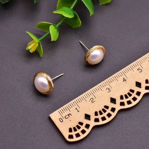 Handcrafted 925 silver pearl stud earrings with gold wire wrap on a dark base