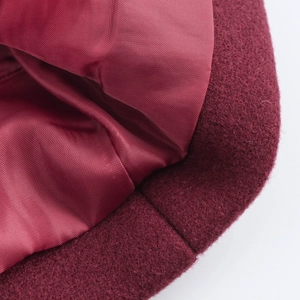 Detail of burgundy wool coat showing high-quality fabric texture and silky inner lining