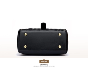 Detail view of the black quilted leather bag bottom with four gold protective metal feet