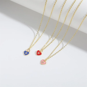 Detailed view of colorful heart pendants with gold chains in red, pink, and blue enamel