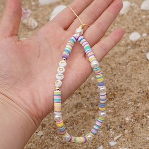 Macro view of Bohemian phone strap with colorful clay beads and LOVE letter charms