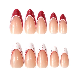 French almond press-on nails with red and white polka dots and delicate bow designs