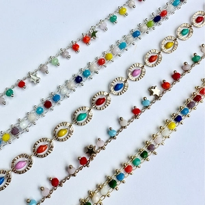 Colorful Bohemian gold-plated chains with multicolored beads and star charms on white background
