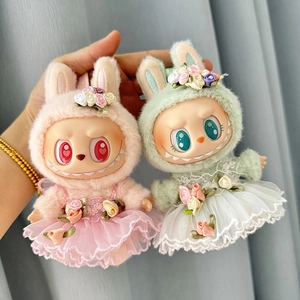 Detail of plush doll outfits featuring pink and green floral headpieces with tulle skirts