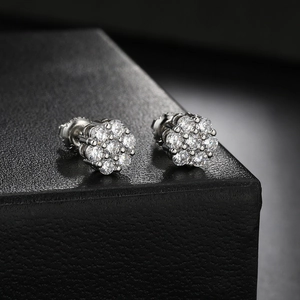 Close-up of silver flower stud earrings featuring pavé-set shimmering zircon stones