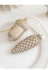 Gros plan d'ornements gland et pomme de pin dorés pailletés avec rubans