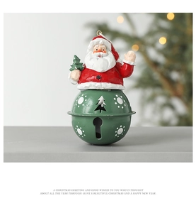 Detail of Santa Claus figure on a green metal bell with white snowflake patterns