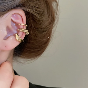 Gros plan sur l'ensemble de bagues d'oreille dorées avec texture de lave et détails