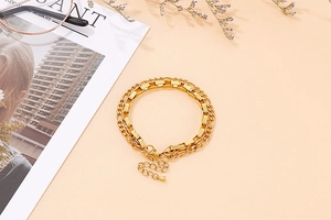 Close-up of double-layer gold stainless steel bracelet with square and flat chain links