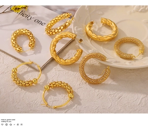 Detail of assorted gold plated hoop earrings with twisted and textured geometric patterns