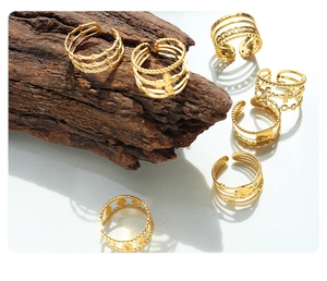 Detalle de varios anillos abiertos bañados en oro con diseños calados y de cadena
