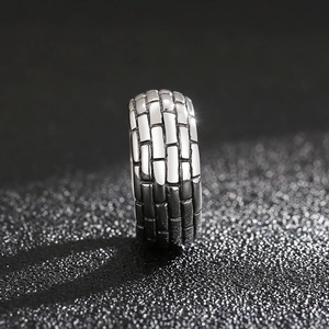 Macro shot of men's punk square ring featuring vintage brick texture and oxidized finish