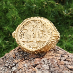 Vintage gold stainless steel Liberty 1983 signet ring on natural wood background