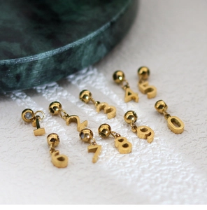 Detailed view of polished gold numerical pendants zero to nine on a textured background
