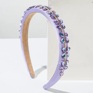 Baroque style purple satin headband with sparkling rhinestones on a minimalist white stand