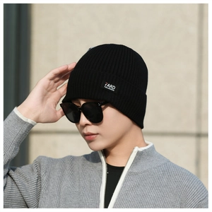 Close-up of black ribbed knit beanie featuring a square FARD brand logo label on the side