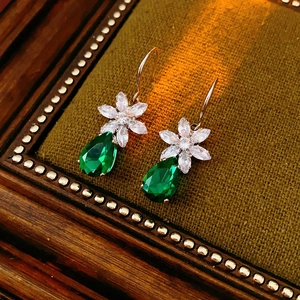 Détail de boucles d'oreilles fleur en zircon avec pendentifs vert goutte d'eau rétro