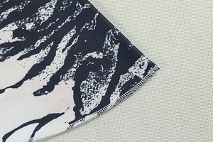 Detailed close-up of overlock stitching on zebra print wide-leg pants fabric texture