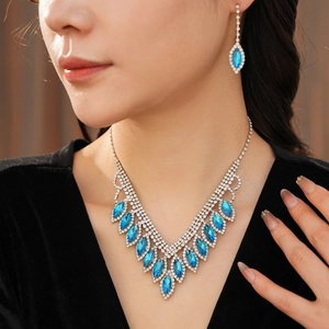 Close-up of elegant blue teardrop fringe necklace and earrings set worn by a model