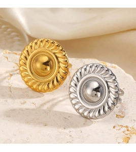 Macro shot of vintage gold and silver dome rings on a textured stone display pedestal