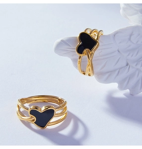 Détail de la bague multicouche en acier titane doré avec un cœur en émail noir