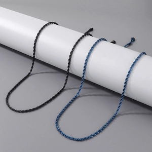 Detail shot of black and blue twist rope chains on a minimalist white cylinder display