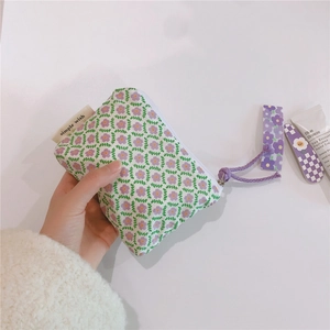 Detailed close-up of a floral cotton mini pouch with purple flowers and a simple wish tag