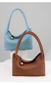 Detailed weave pattern on blue and brown leather tote bags with gold orb charms