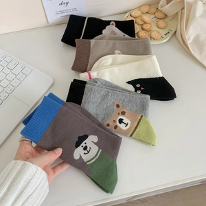 Flat lay of colorful combed cotton socks featuring cute cartoon animal character embroidery
