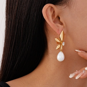 Elegant gold leaf drop earrings with sparkling zircon and a white teardrop pearl on model